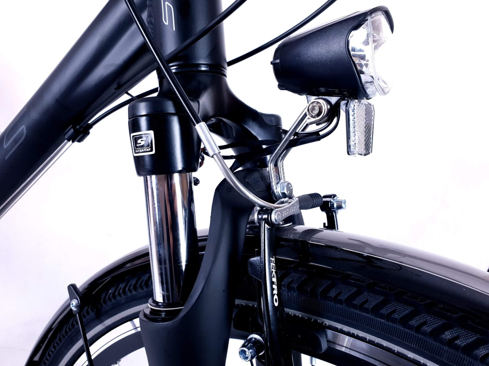 Närbild av cykels framlykta och framgaffel.