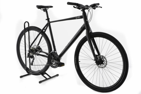 Svart cykel på cykelställ mot vit bakgrund.