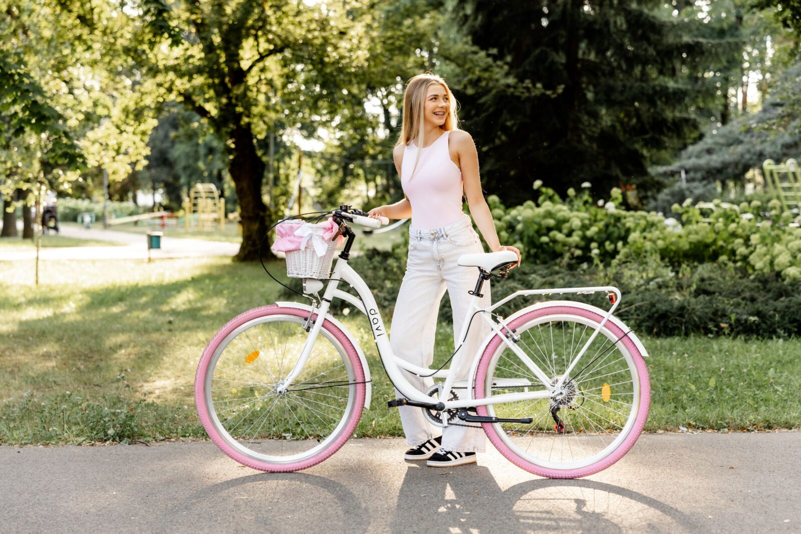 Kvinna med cykel i soligt parklandskap