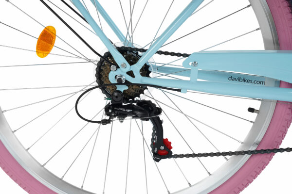 Närbild cykelhjul med blå ram och rosa däck.