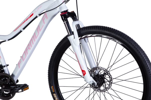 Vit mountainbike med skivbromsar och däck i närbild.