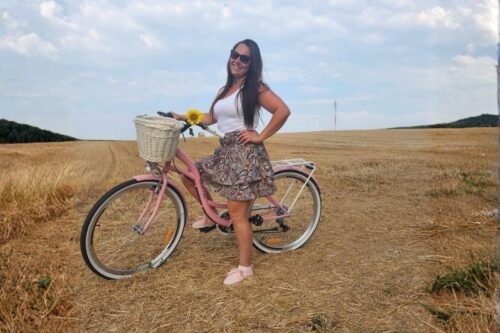 Žena na ružovom bicykli v prírode